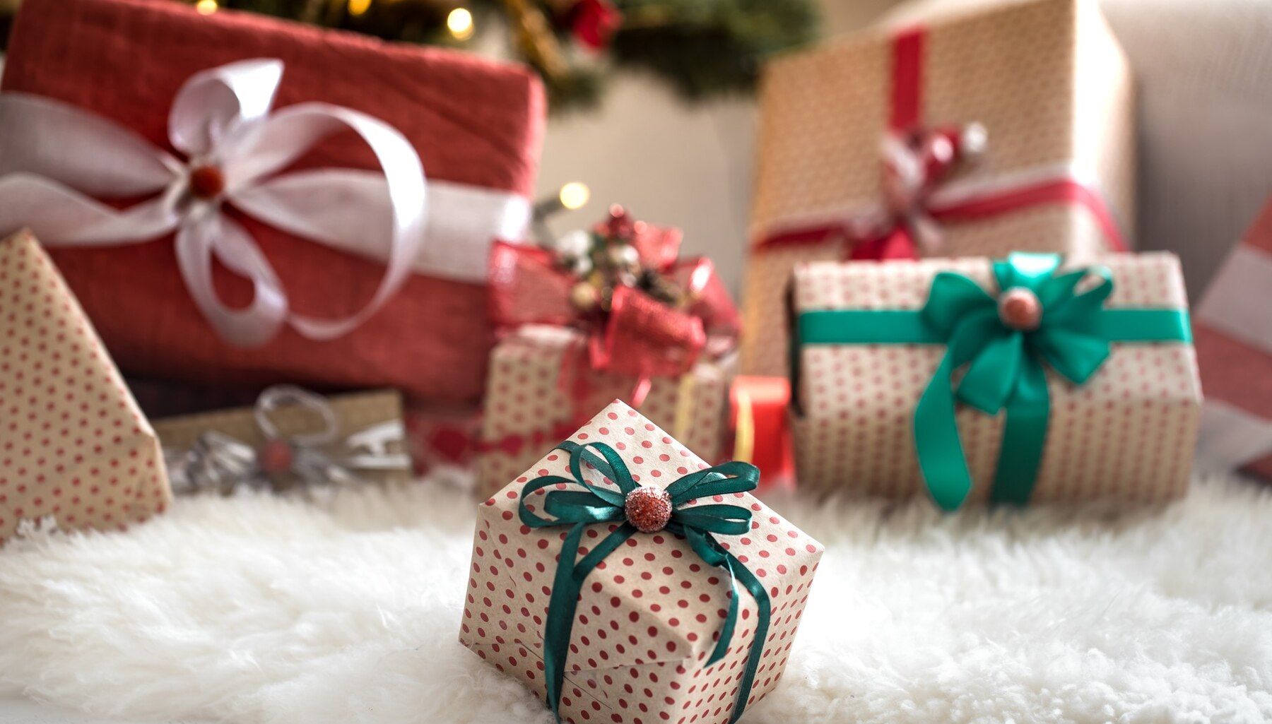 monton-regalos-navidad-sobre-pared-ligera-sobre-mesa-madera-alfombra-acogedora-decoraciones-navidad_169016-5675.jpg